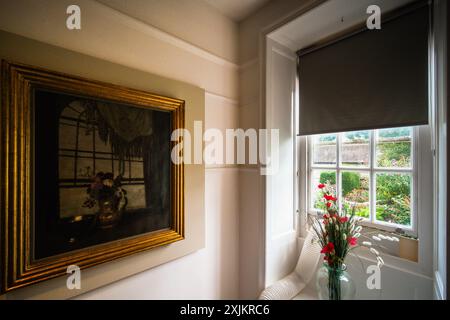 Zinnias et une peinture de bol satiné - éclairé par la fenêtre d'où peut être vu le studio à travers le jardin dans whist il a été peint photographié pendant la vue de presse - Prydie: la vie et l'art de Mabel Pryde Nicholson le jeudi 18 juillet 2024 à la Grange Gallery , Rottingdean. Organisée par David Bomford et Lucy Davies, l’exposition rassemble près de 30 objets de collections privées et d’institutions nationales, dont des portraits de l’artiste par son mari William et des lettres poignantes, des photographies et des objets personnels, presque tous invisibles depuis la mort de Mabel en Floride espagnole Banque D'Images