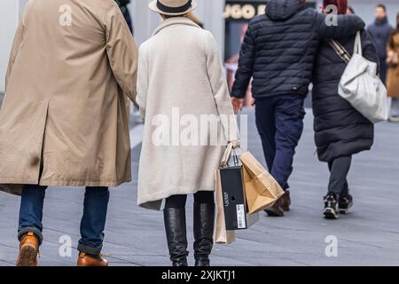 Les touristes grand public traînant des sacs à provisions, magasin d'usine, Outletcity Metzingen avec environ 80 magasins avec des marques premium et de luxe spécialisées dans Banque D'Images