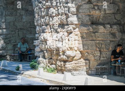 (240719) -- ISTANBUL, 19 juillet 2024 (Xinhua) -- les gens reposent sous l'aqueduc de Valens à Istanbul, T¨¹rkiye, 18 juillet 2024. L'aqueduc de Valens est un important aqueduc romain antique à Istanbul. Dans le cadre d'un plus grand système d'approvisionnement en eau, il a été achevé à la fin du IVe siècle après JC sous le règne de l'empereur romain Valens, d'après qui il porte le nom. La structure est remarquable pour son ingénierie impressionnante et sa conception architecturale. L'aqueduc a été construit en utilisant une combinaison de pierre et de brique, et il comporte une série d'arches qui soutiennent le canal d'eau au-dessus. Aujourd'hui, l'aqueduc Banque D'Images