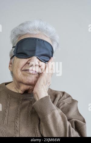 Une femme âgée portant un masque de sommeil Banque D'Images