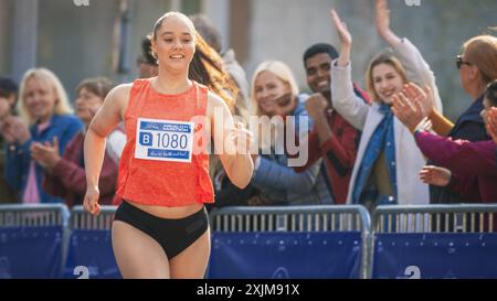 Portrait d'une femme qui court et participe à un marathon dans un parc. Strong Athletic Female Jogger Racing autres coureurs avec détermination pour la première place dans la ligne d'arrivée Banque D'Images