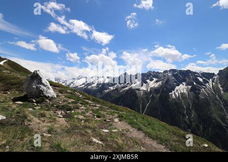 Vue depuis une pente de montagne sur le Filzenkogel jusqu'aux Alpes du Zillertal avec un rocher au premier plan, vue grand angle Banque D'Images