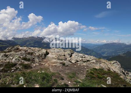 Vue de roche stérile avec des chaînes de montagnes en arrière-plan, ciel bleu nuageux, plan grand angle Banque D'Images