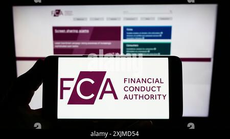 Stuttgart, Allemagne, 05 26 2022 : personne tenant un smartphone avec le logo de la British Financial Conduct Authority (FCA) sur l'écran devant le site Web. Mise au point Banque D'Images