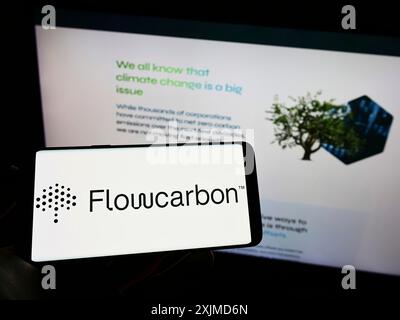 Stuttgart, Allemagne, 05 26 2022 : personne tenant un téléphone portable avec le logo de la société américaine Flow Carbon Inc (Flowcarbon) sur l'écran devant l'entreprise Banque D'Images