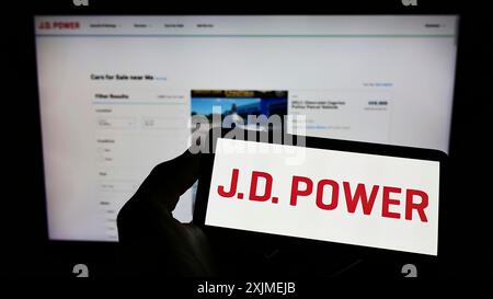 Stuttgart, Allemagne, 06-011-2022 : personne tenant un téléphone portable avec le logo de la société américaine de recherche sur la consommation J.D. Power sur l'écran devant la page Web de l'entreprise. Banque D'Images