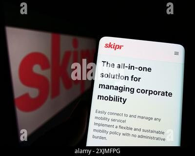 Stuttgart, Allemagne, 06-19-2022 : personne tenant un téléphone portable avec la page web de la société belge de mobilité Skipr sa sur l'écran devant le logo. Concentrez-vous sur Banque D'Images