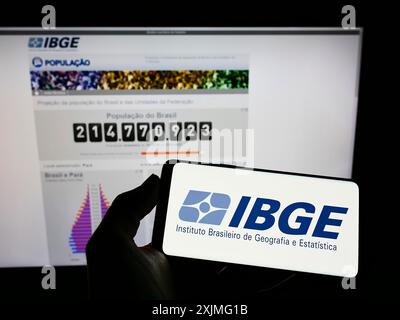 Stuttgart, Allemagne, 06-25-2022, personne tenant un smartphone avec le logo de l'Instituto Brasileiro de Geografia e Estatistica (IBGE) sur l'écran avec le site web. Banque D'Images