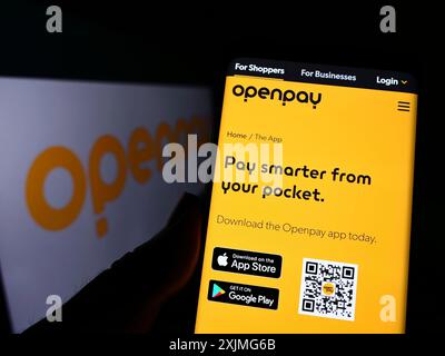 Stuttgart, Allemagne, 07-03-2022 : personne tenant un téléphone portable avec la page Web de la société australienne de fintech Openpay Group Limited sur l'écran avec logo. Mise au point Banque D'Images