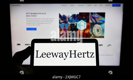 Stuttgart, Allemagne, 07-13-2022 : personne tenant un smartphone avec le logo de la société américaine de blockchain LeewayHertz sur l'écran devant le site Web. Concentrez-vous sur Banque D'Images