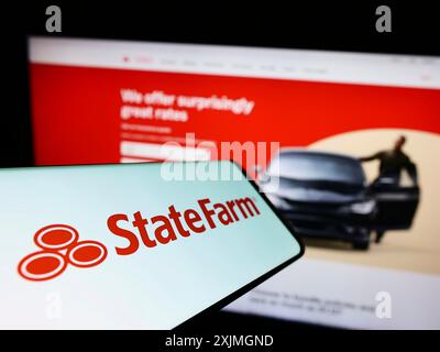 Stuttgart, Allemagne, 07-16-07 2022 : smartphone avec le logo de State Farm Mutual automobile Insurance Company sur l'écran devant le site Web de l'entreprise. Mise au point Banque D'Images