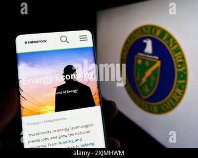 Stuttgart, Allemagne, 07-24-2022 : personne tenant un smartphone avec la page Web du Département de l'énergie des États-Unis (DOE) sur l'écran devant le joint. Mise au point Banque D'Images