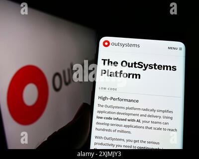 Stuttgart, Allemagne, 07-31-2022, personne tenant un téléphone portable avec la page web de la société de logiciels low-code OutSystems sur l'écran devant le logo. Concentrez-vous sur Banque D'Images