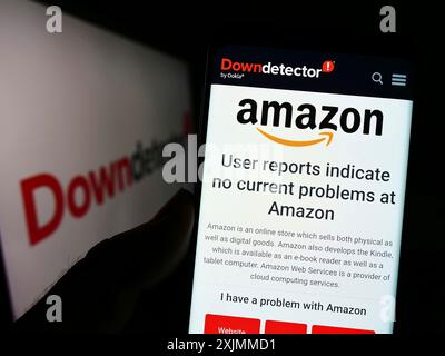Stuttgart, Allemagne, 09-08-2022 : personne tenant un smartphone avec le site web de la plateforme Downdetect et le statut Amazon devant le logo. Concentrez-vous sur le téléphone Banque D'Images