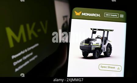 Stuttgart, Allemagne, 09-08-2022 : personne tenant le téléphone portable avec la page web et le logo de la société Zimeno Inc (Monarch Tractor) sur l'écran avec le moniteur. Mise au point Banque D'Images