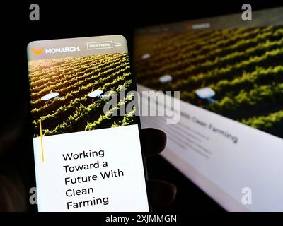 Stuttgart, Allemagne, 09-08-2022 : personne tenant un smartphone avec site web et logo de la société Zimeno Inc (Monarch Tractor) sur l'écran avec moniteur. Banque D'Images