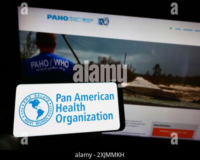 Stuttgart, Allemagne, 09-10-2022 : personne tenant un téléphone portable avec le logo de l'Organisation panaméricaine de la santé (OPS) sur l'écran devant la page Web. Concentrez-vous sur Banque D'Images