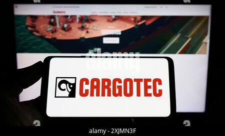 Stuttgart, Allemagne, 09-10-2022 : personne tenant un smartphone avec le logo de la société finlandaise de machines Cargotec Oyj sur l'écran en face du site Web. Concentrez-vous sur Banque D'Images