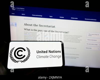 Stuttgart, Allemagne, 09-24-2022 : personne tenant un smartphone avec le logo du traité des Nations Unies sur l'environnement CCNUCC sur l'écran devant le site Web. Banque D'Images