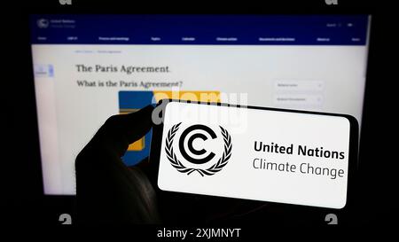Stuttgart, Allemagne, 09-24-2022 : personne tenant un téléphone portable avec le logo du traité des Nations Unies sur l'environnement CCNUCC sur l'écran en face de la page Web. Mise au point Banque D'Images