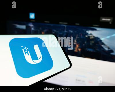 Stuttgart, Allemagne, 09-24-2022 : personne tenant un smartphone avec le logo de la société de technologie américaine Ubiquiti Inc. sur l'écran devant le site Web. Mise au point Banque D'Images