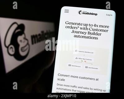 Stuttgart, Allemagne, 09-24-2022 : personne tenant un smartphone avec la page web de la plate-forme d'automatisation marketing Mailchimp sur l'écran devant le logo. Mise au point Banque D'Images