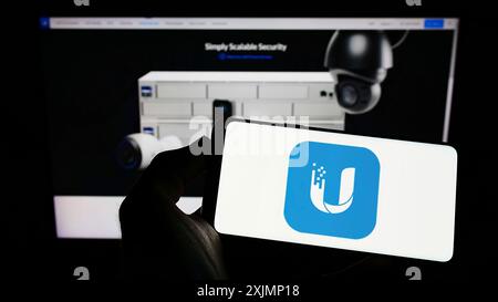 Stuttgart, Allemagne, 09-24-2022 : personne tenant un téléphone portable avec le logo de la société de technologie américaine Ubiquiti Inc. sur l'écran en face de la page Web de l'entreprise. Banque D'Images