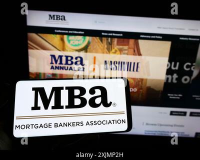 Stuttgart, Allemagne, 09 25 2022 : personne tenant un smartphone avec le logo de l'organisation Mortgage Bankers Association (MBA) sur l'écran devant le site Web. Banque D'Images