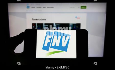 Stuttgart, Allemagne, 09-30-2022, personne tenant un téléphone portable avec le logo de la Federatie Nederlandse Vakbeweging (FNV) néerlandaise sur l'écran devant la page web. Banque D'Images