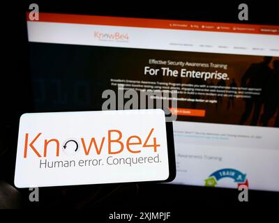 Stuttgart, Allemagne, 09-26-2022, personne tenant un smartphone avec le logo de la société américaine de sensibilisation à la sécurité KnowBe4 Inc sur l'écran devant le site Web. Banque D'Images