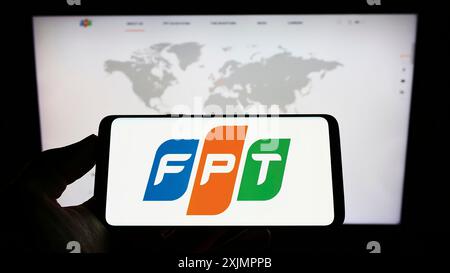 Stuttgart, Allemagne, 10-01-2022 : personne tenant un téléphone portable avec le logo de la société INFORMATIQUE vietnamienne FPT Corporation sur l'écran en face de la page Web de l'entreprise. Banque D'Images