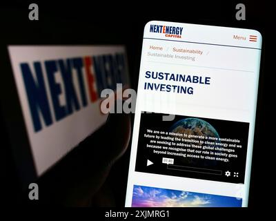 Stuttgart, Allemagne, 03-10-2022 : personne tenant un smartphone avec la page web de la société britannique NextEnergy Capital Limited sur l'écran devant le logo. Banque D'Images