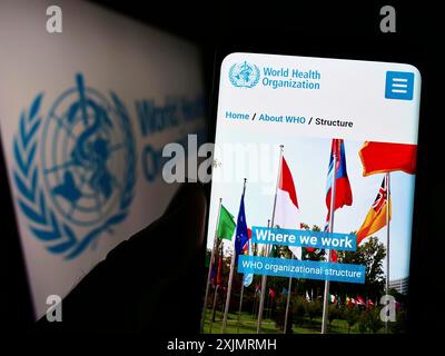 Stuttgart, Allemagne, 10-09-2022 : personne tenant un téléphone portable avec le site Web de l'Organisation mondiale de la santé (OMS) de l'ONU sur l'écran devant le logo. Mise au point Banque D'Images