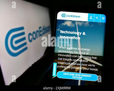 Stuttgart, Allemagne, 10-09-2022 : personne tenant un téléphone portable avec la page web de la société américaine Consolidated Edison Inc (conEdison) sur l'écran avec le logo. Mise au point Banque D'Images