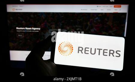 Stuttgart, Allemagne, 10-14-2022 : personne tenant un smartphone avec le logo de l'agence de presse Reuters sur l'écran devant le site. Concentrez-vous sur l'affichage du téléphone Banque D'Images