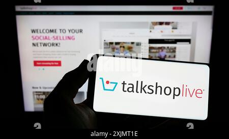 Stuttgart, Allemagne, 10-15-2022 : personne tenant un smartphone avec le logo de la société américaine de vente sociale TalkShopLive Inc sur l'écran devant le site Web. Banque D'Images