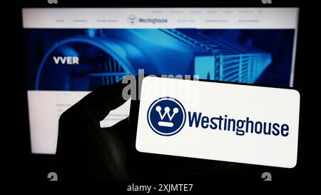 Stuttgart, Allemagne, 10 26 2022 : personne tenant un téléphone portable avec le logo de Westinghouse Electric Company LLC sur l'écran devant la page Web de l'entreprise. Mise au point Banque D'Images