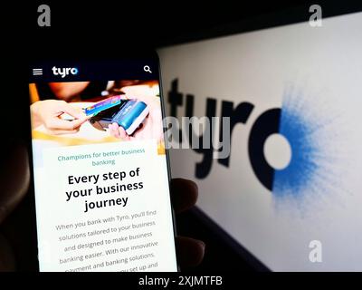 Stuttgart, Allemagne, 10-24-2022 : personne tenant le téléphone portable avec la page Web de la société fintech australienne Tyro Payments Limited sur l'écran avec le logo. Mise au point Banque D'Images