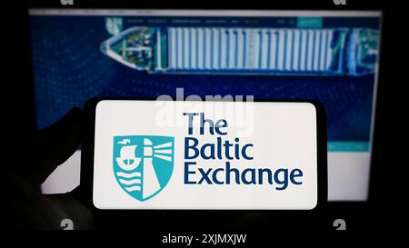 Stuttgart, Allemagne, 12-14-2022 : personne tenant un smartphone avec le logo de la société britannique The Baltic Exchange Limited sur l'écran devant le site Web. Banque D'Images