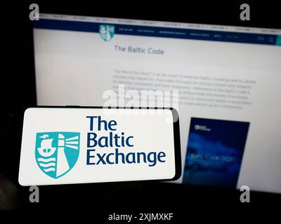 Stuttgart, Allemagne, 12-14-2022 : personne tenant un téléphone portable avec le logo de la société britannique The Baltic Exchange Limited sur l'écran devant l'entreprise Banque D'Images