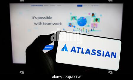 Stuttgart, Allemagne, 12 30 2022 : personne tenant un smartphone avec le logo de la société australienne de logiciels Atlassian Corporation sur l'écran devant Banque D'Images