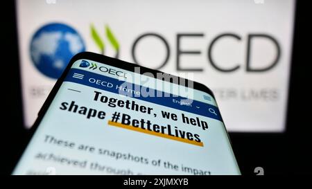Stuttgart, Allemagne, 12-23-2022 : téléphone portable avec le site web de l'organisation intergouvernementale OCDE sur l'écran devant le logo. Concentrez-vous sur le coin supérieur gauche de Banque D'Images