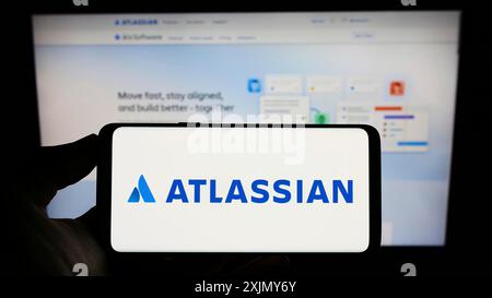 Stuttgart, Allemagne, 12 30 2022 : personne tenant un téléphone portable avec le logo de la société australienne de logiciels Atlassian Corporation sur l'écran devant Banque D'Images