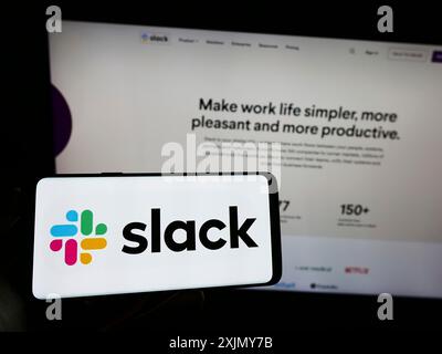 Stuttgart, Allemagne, 12 30 2022 : personne tenant un téléphone portable avec le logo de la société américaine de logiciels Slack technologies LLC sur l'écran devant l'entreprise Banque D'Images