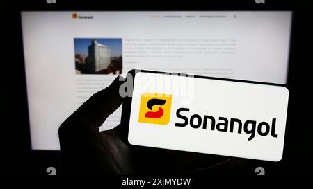 Stuttgart, Allemagne, 01-06-2023 : personne tenant un smartphone avec le logo de la société pétrolière angolaise Group Sonangol sur l'écran devant le site Web. Mise au point Banque D'Images