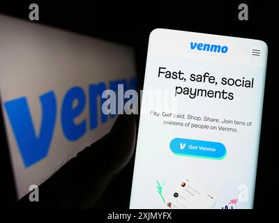 Stuttgart, Allemagne, 12-31-2022, personne tenant un téléphone portable avec la page web du service de paiement mobile Venmo sur l'écran devant le logo de la société. Concentrez-vous sur Banque D'Images