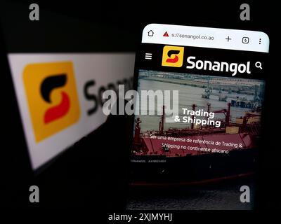 Stuttgart, Allemagne, 01-06-2023 : personne tenant un téléphone portable avec le site Web de la compagnie pétrolière angolaise Groupe Sonangol sur l'écran devant le logo. Mise au point Banque D'Images