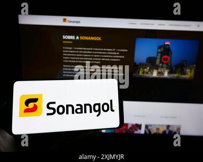 Stuttgart, Allemagne, 01-06-2023 : personne tenant un téléphone portable avec le logo de la société pétrolière angolaise Groupe Sonangol sur l'écran devant le web d'affaires Banque D'Images