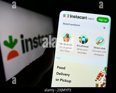 Stuttgart, Allemagne, 01-07-2023 : personne tenant un téléphone portable avec la page Web de la société américaine de vente au détail Maplebear Inc (Instacart) sur l'écran avec le logo. Concentrez-vous sur Banque D'Images