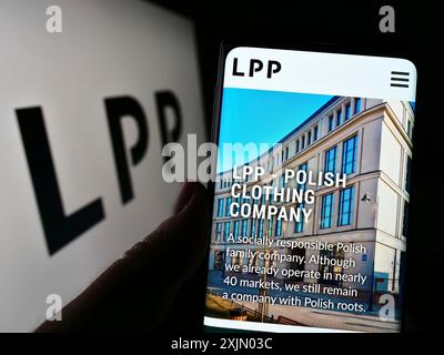 Stuttgart, Allemagne, 12 25 2022 : personne tenant un smartphone avec le site de la société polonaise de vente au détail de vêtements LPP S.A. sur l'écran devant le logo. Mise au point Banque D'Images